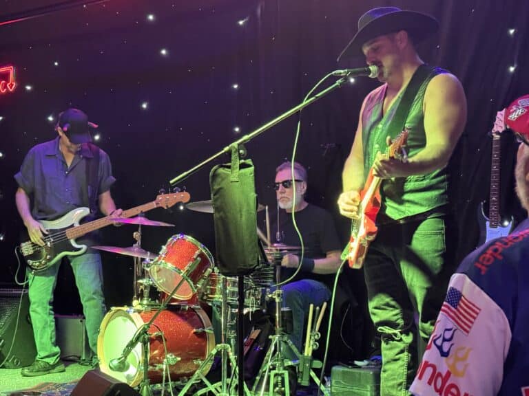 Mountain harbours live music performance with musicians playing guitars and drums at night.