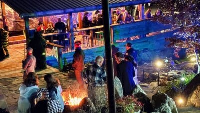 Fire pit with people enjoying outdoor event at Mountain Harbour.