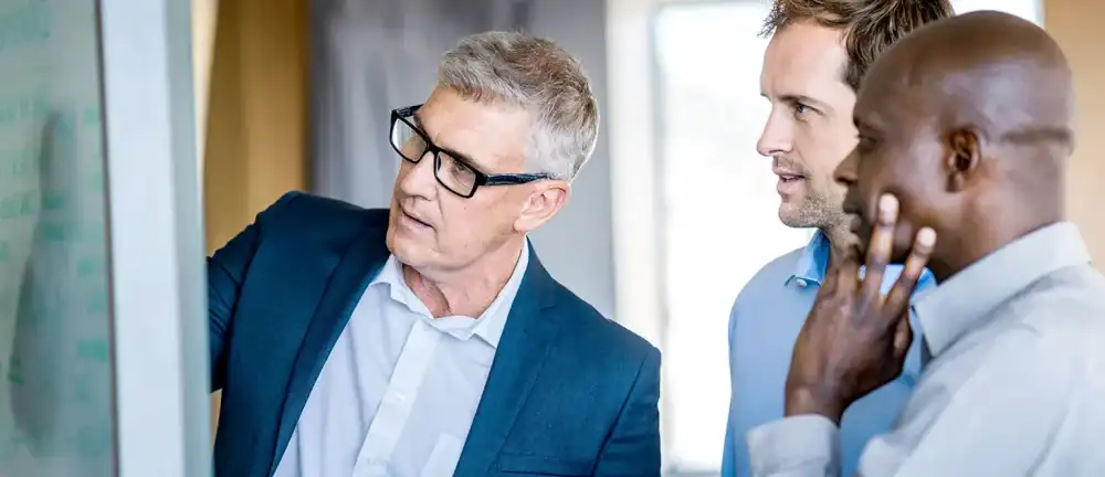 Fractional CMO leading strategy session with executive team at whiteboard.