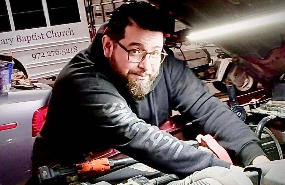 Automotive technician working on a car engine at Murdock & Son Automotive.