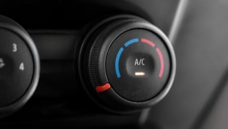 Close-up of car A/C control knob with temperature settings.