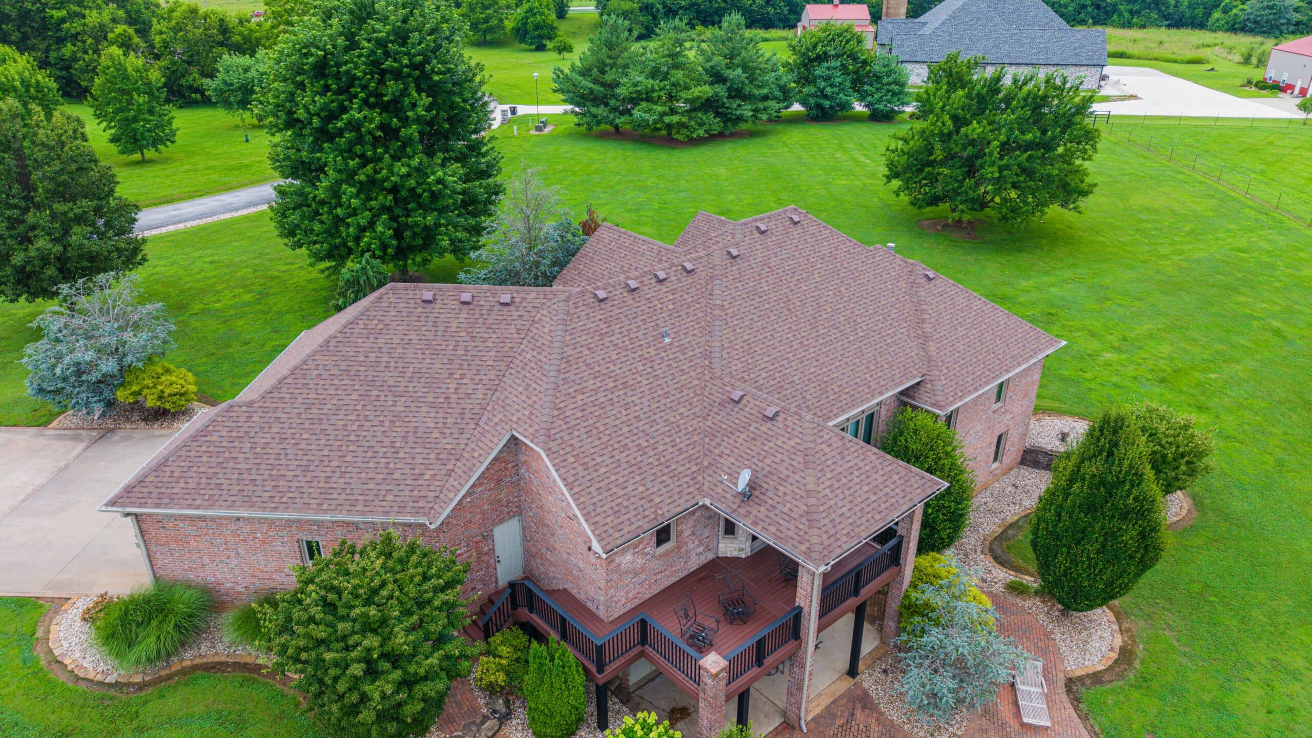 Professional roofing installation on a residential home with new shingles in Midwest area.