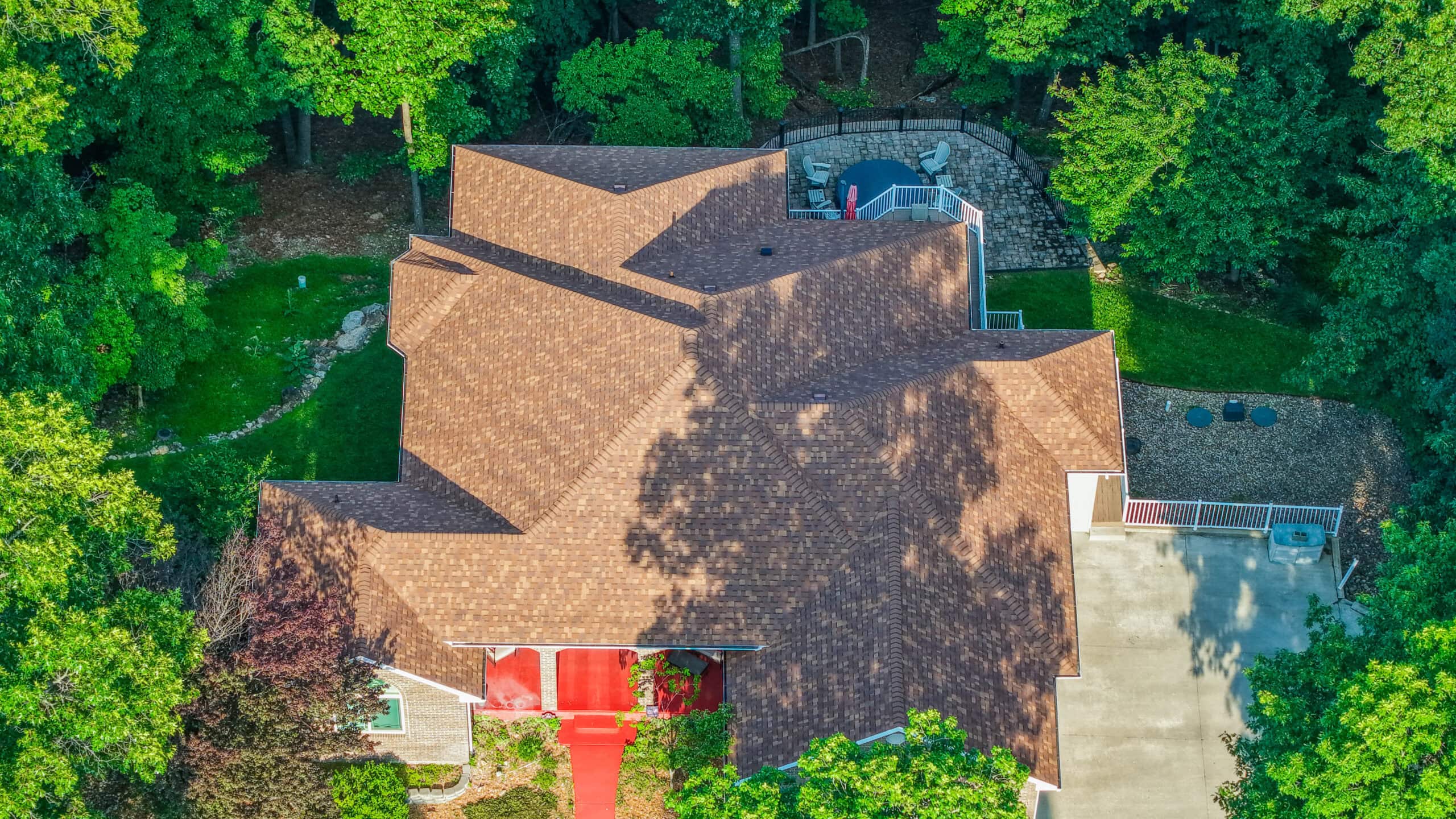 Aerial view of a residential roofing project with new shingles installed.