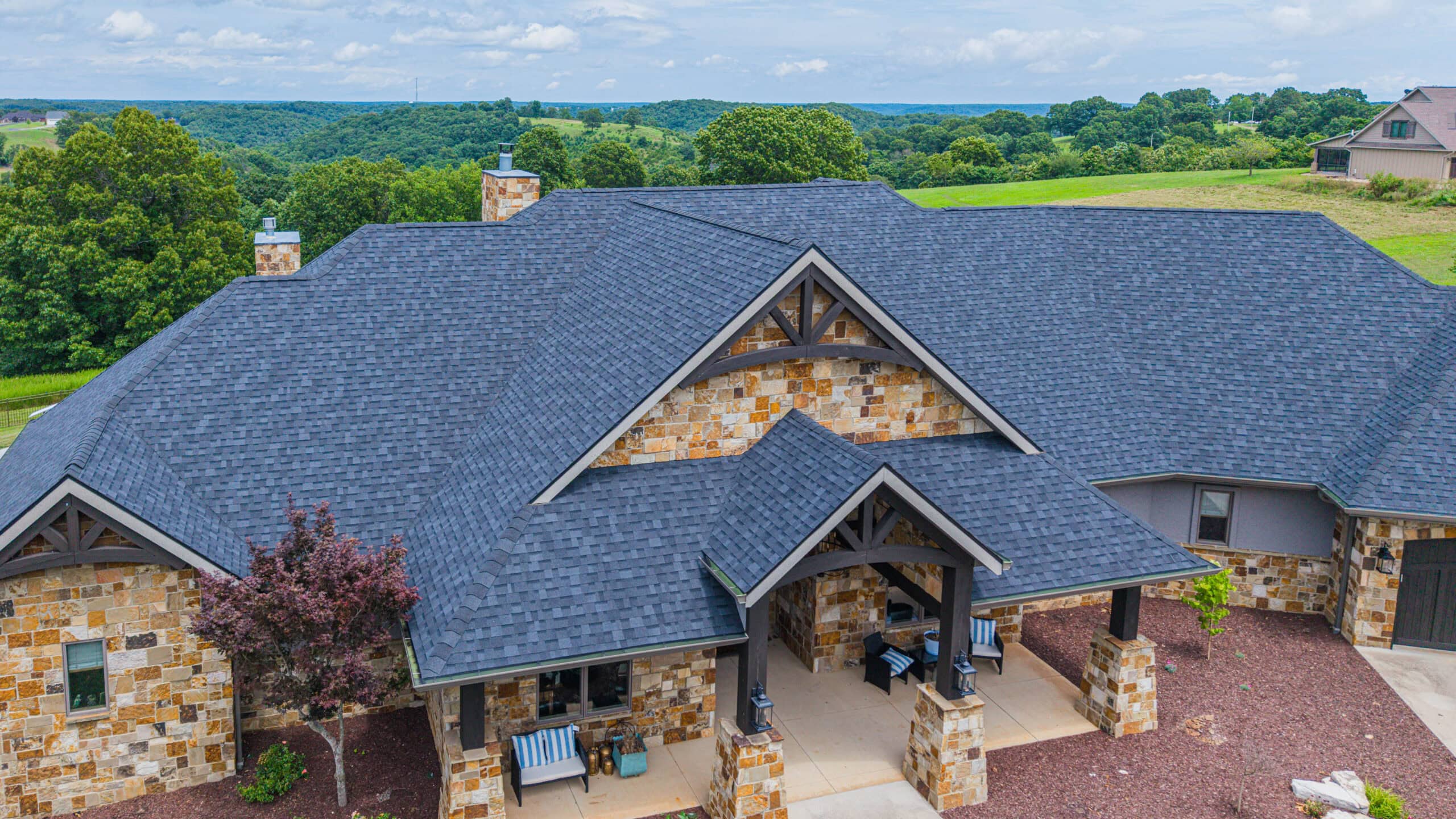 Professional roofing installation on a large residential home with durable asphalt shingles.