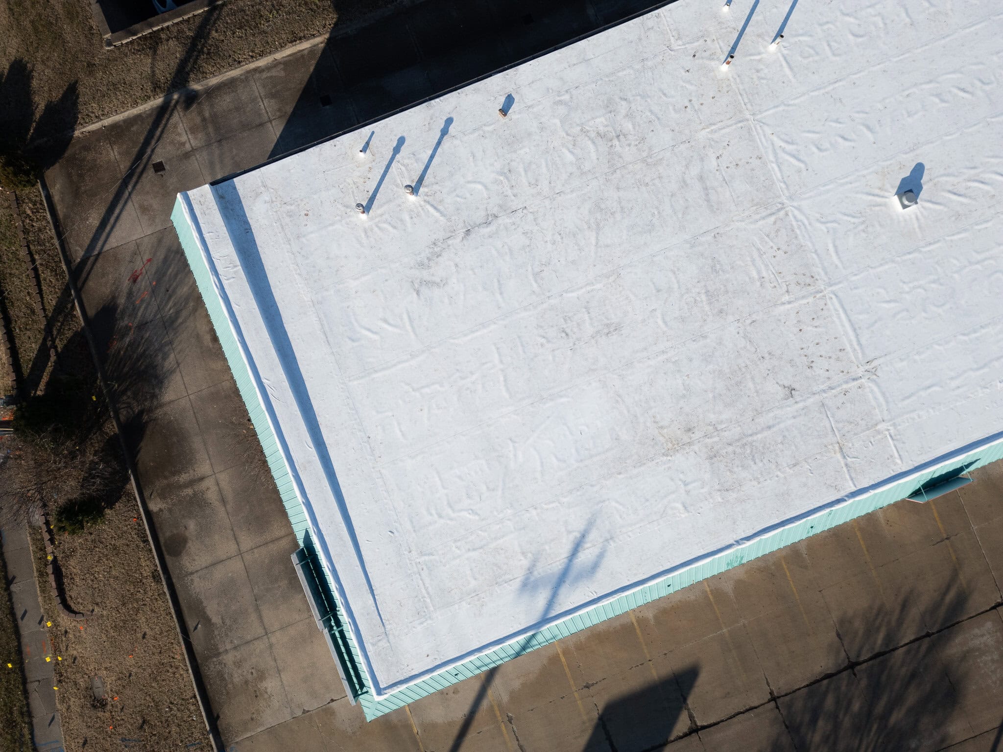 Aerial view of a commercial roofing project in Columbia, MO with white roofing membrane.