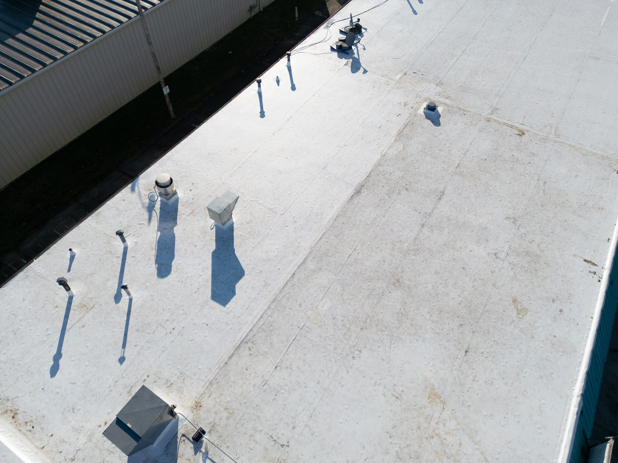 Aerial view of a flat commercial roof with roofing vents and equipment in Columbia, MO.