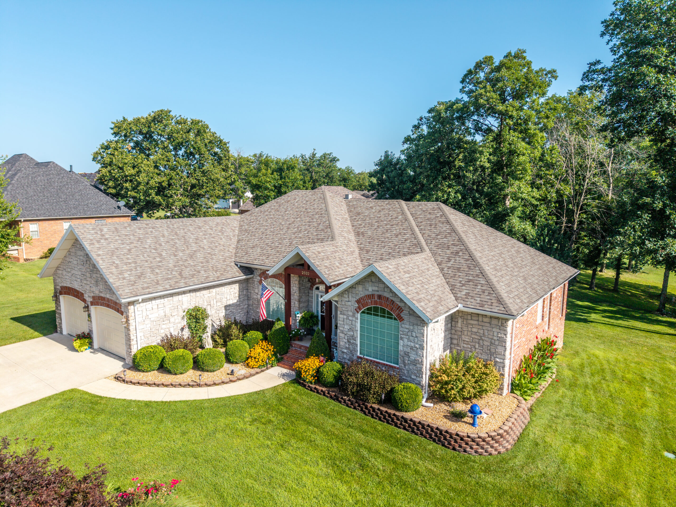 Modern home with new roofing and lush landscaping in Lebanon, MO.