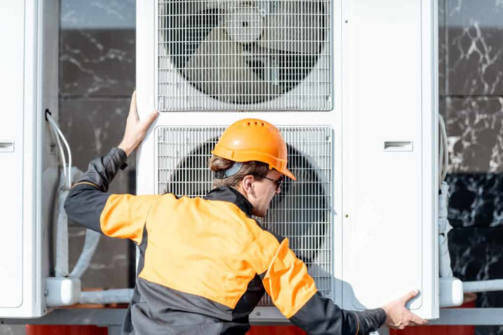 HIGH-QUALITY HVAC TECHNICIAN INSPECTING AN AIR CONDITIONING UNIT FOR REPAIR OR MAINTENANCE SERVICE.