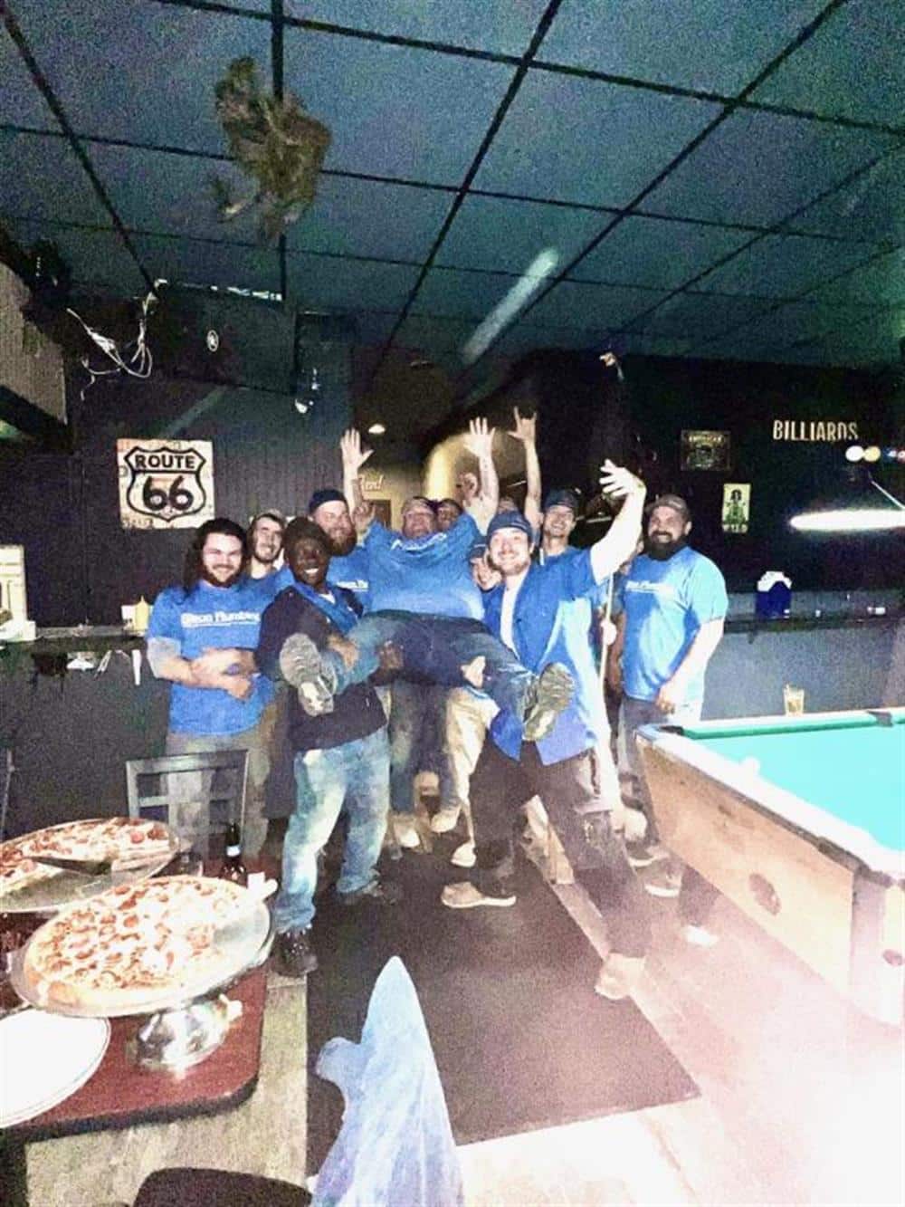 The Bison Plumbing crew in matching blue company shirts posing together at a team gathering