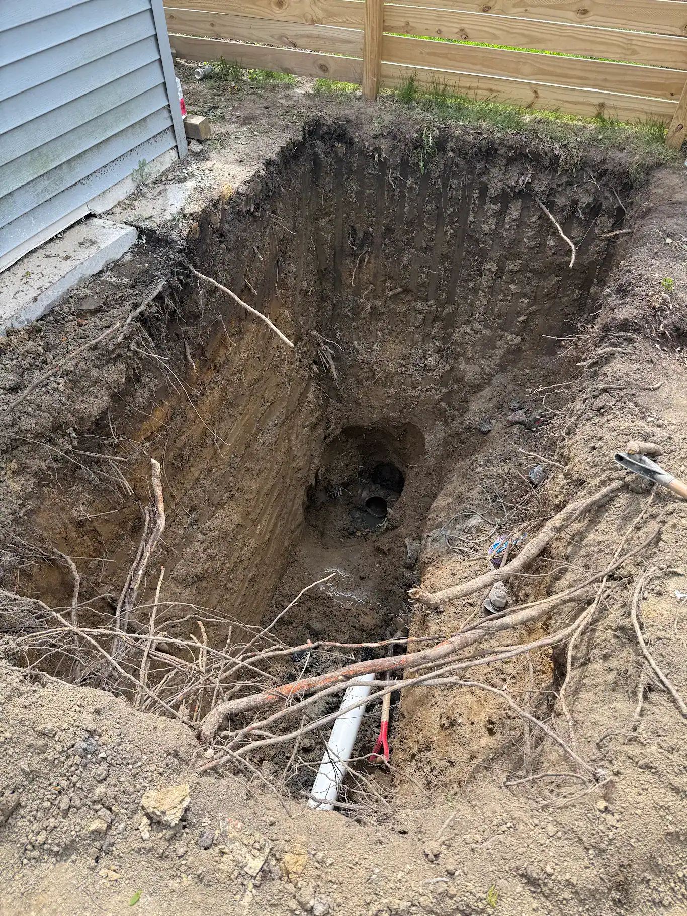 An open sewer excavation showing the depth a Metro Detroit lateral sits at, with the pipe exposed at the base of the pit