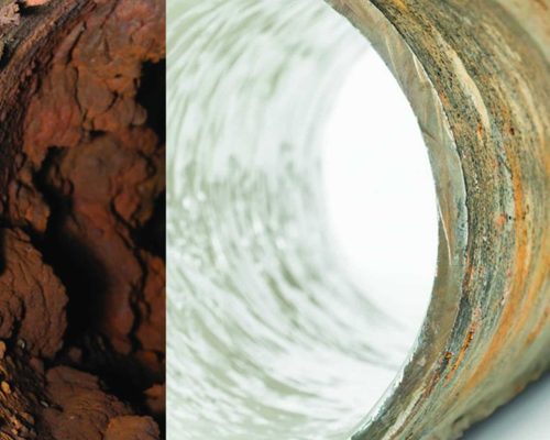 A metal pipe is shown split in half; the left side is clogged with rust and debris, while the right side is clean—a clear example of why homeowners trust plumbers in Warren MI to keep their pipes clear and functioning.