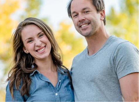 Happy couple during outdoor photoshoot in autumn, smiling and enjoying nature.