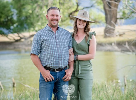 Vibrant outdoor portrait of a smiling couple enjoying nature by a river, showcasing professional engagement and family photography services at My Roots Photography.