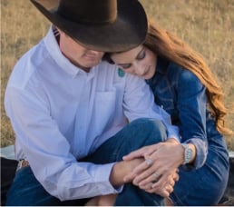 A loving couple embracing outdoors during sunset, showcasing candid engagement or wedding photography.