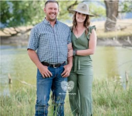 Portrait of a happy couple standing outdoors by a pond, capturing love and connection for engagement or couple photos, in a natural scenic setting.