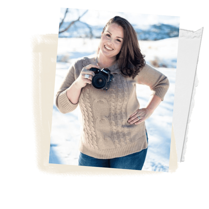 Vibrant woman holding a camera outdoors in a snowy landscape, professional photographer, winter photoshoot, candid portrait, natural lighting, smiling female photographer, outdoor photography, beauty in winter, my roots photography co.