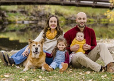 Beautiful family outdoor portrait featuring parents, two children, and a dog near a lake, showcasing professional photography capturing joyful moments and family bonds in nature.