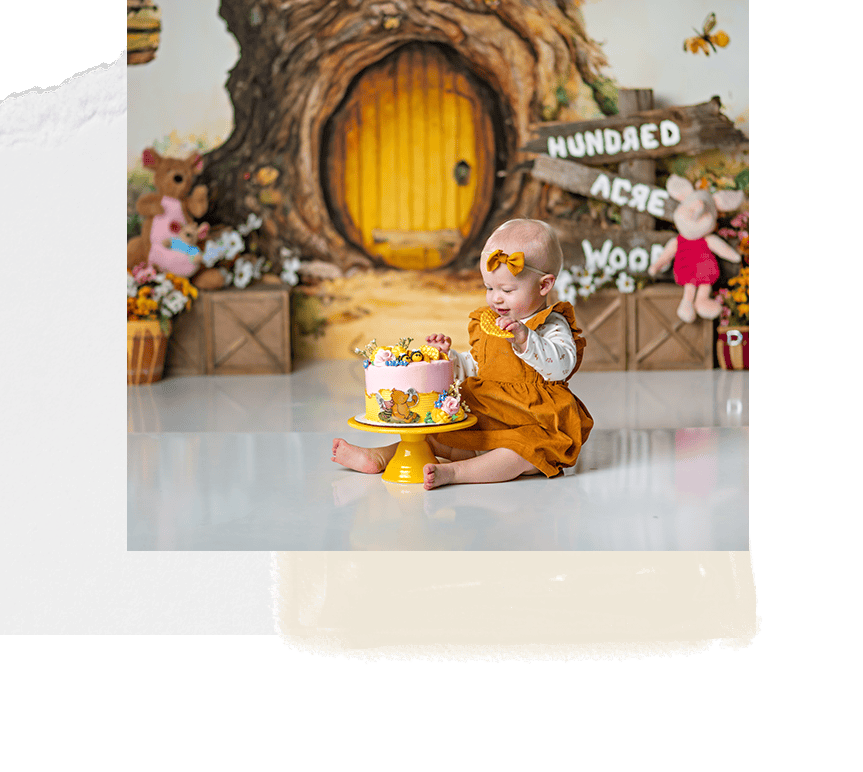 Colorful first birthday cake smash with a baby girl, woodland themed backdrop, celebration decor, and adorable plush toys.