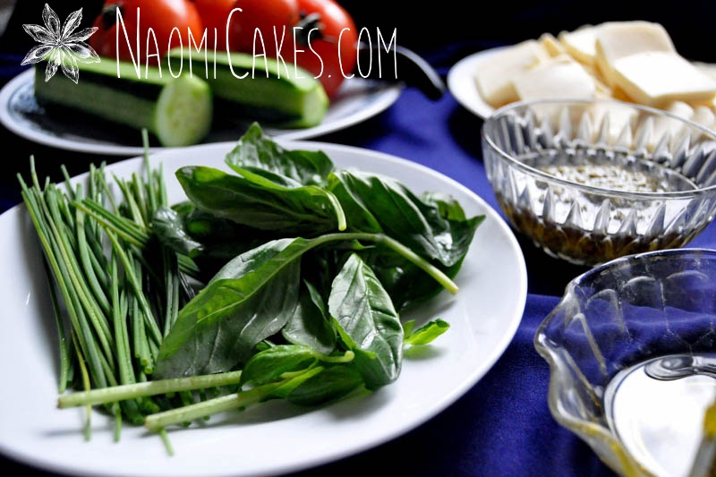 a plate of fresh basil with other cooking ingredients in the background