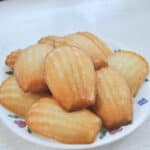 a pile of madeleines on a plate with a white background