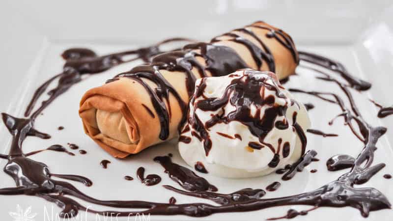 baked mars bar in phyllo pastry on a square plate with chocolate sauce and cream