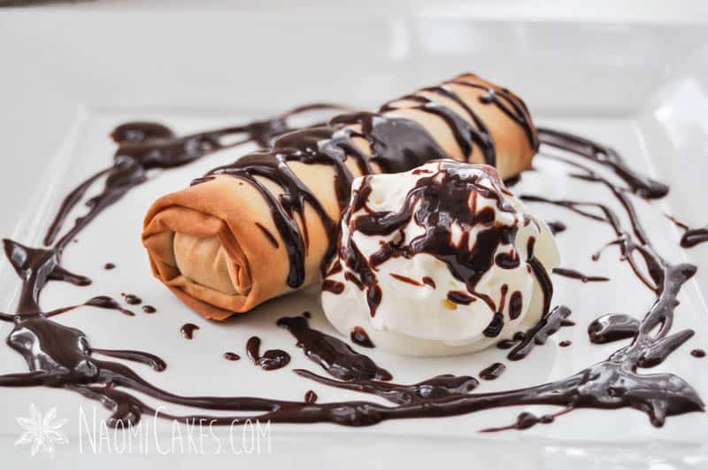 baked mars bar in phyllo pastry on a square plate with chocolate sauce and cream