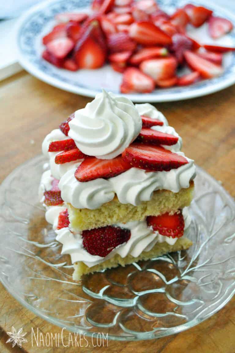 a square mini strawberry shortcake on a glass plate on a cutting board
