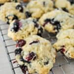 rows of blueberry scones on a cooling rack over a white background