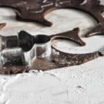 gingerbread cookies being cut on a table dusted with flour