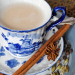 close up image of a blue china tea cup of chai tea with cinnamon stick and star anise