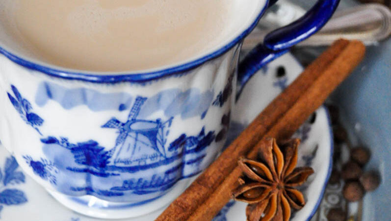 close up image of a blue china tea cup of chai tea with cinnamon stick and star anise