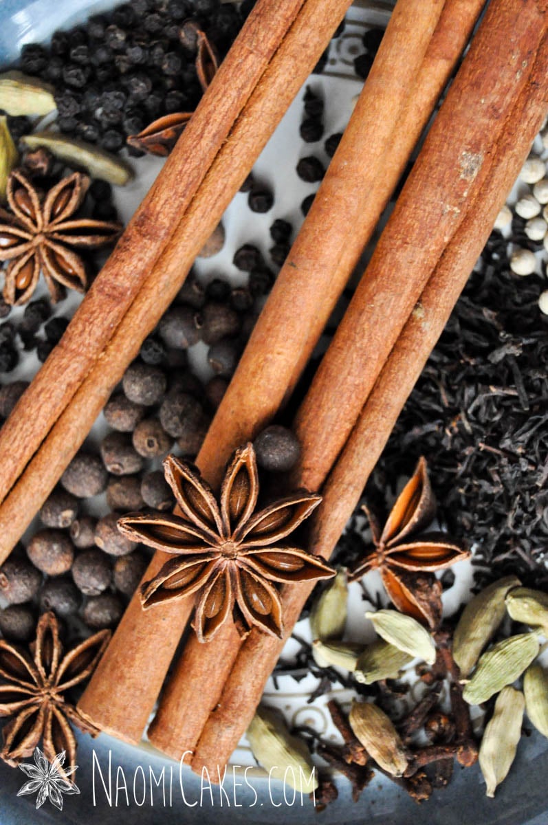 star anise, cinnamon and other chai spices on a blue plate