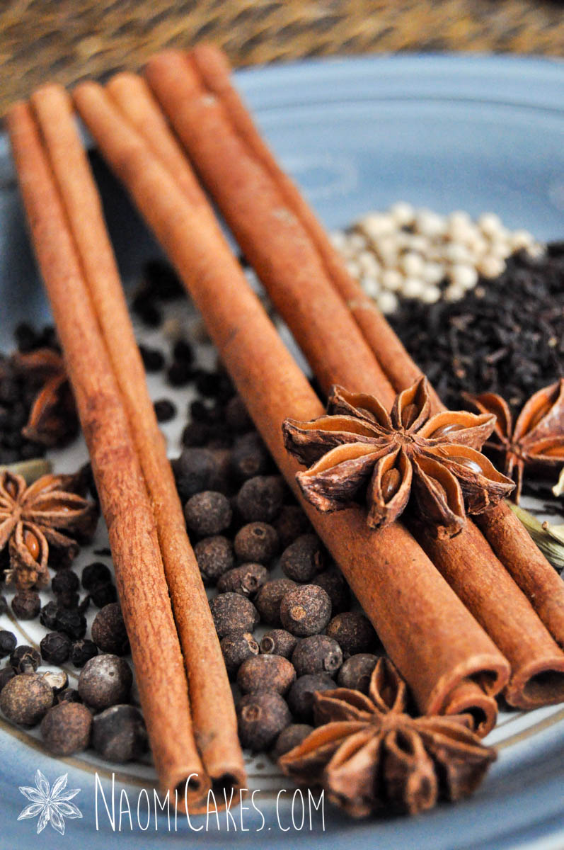 star anise, cinnamon sticks and other whole chai spices on a blue background