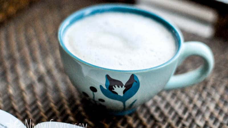 a London fog tea latte in a teal latte mug beside a Bible