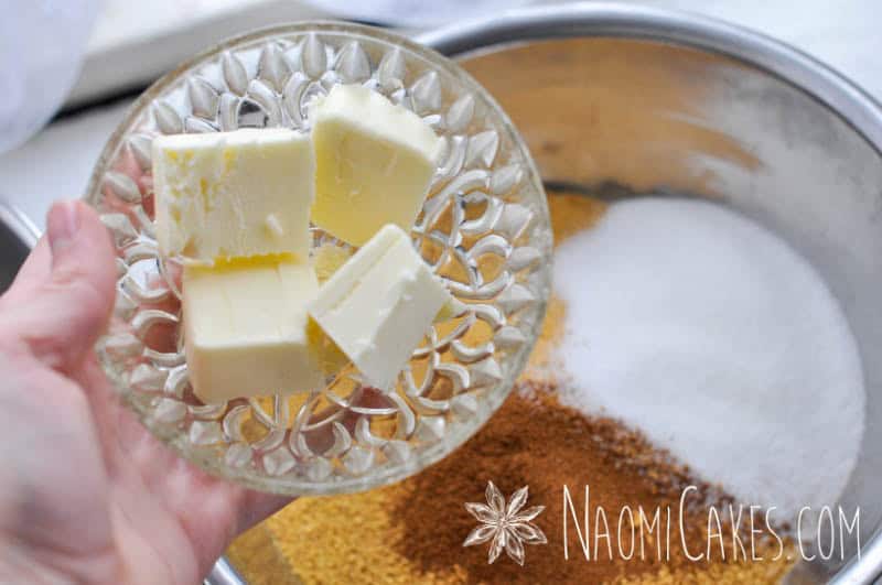 butter in a bowl with other baking ingredients in the background