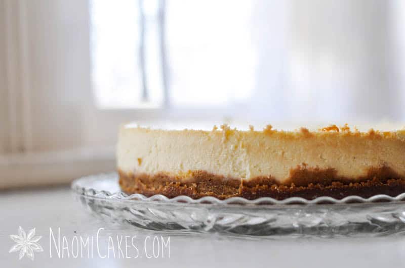 side view of a baked cheesecake on a glass plate