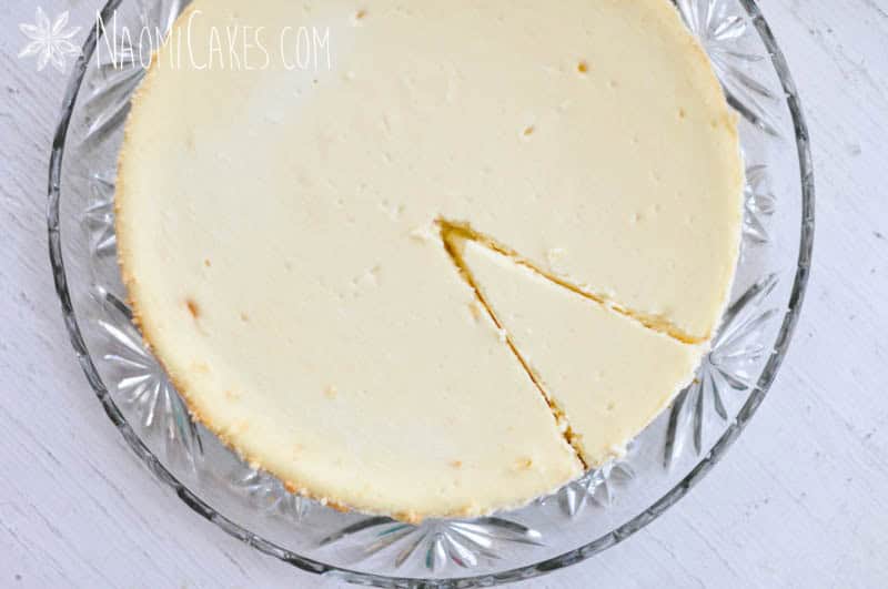 overhead view of a cheesecake with the outline of one cut slice