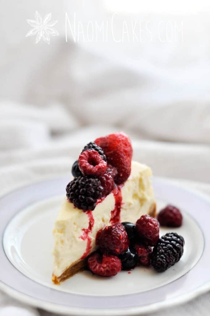 close up slice of cheesecake with frozen fruit on top