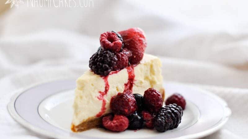 horizontal image of cheesecake with frozen fruit on top