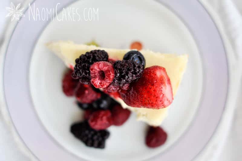 overhead view of a slice of cheesecake with frozen fruit on top
