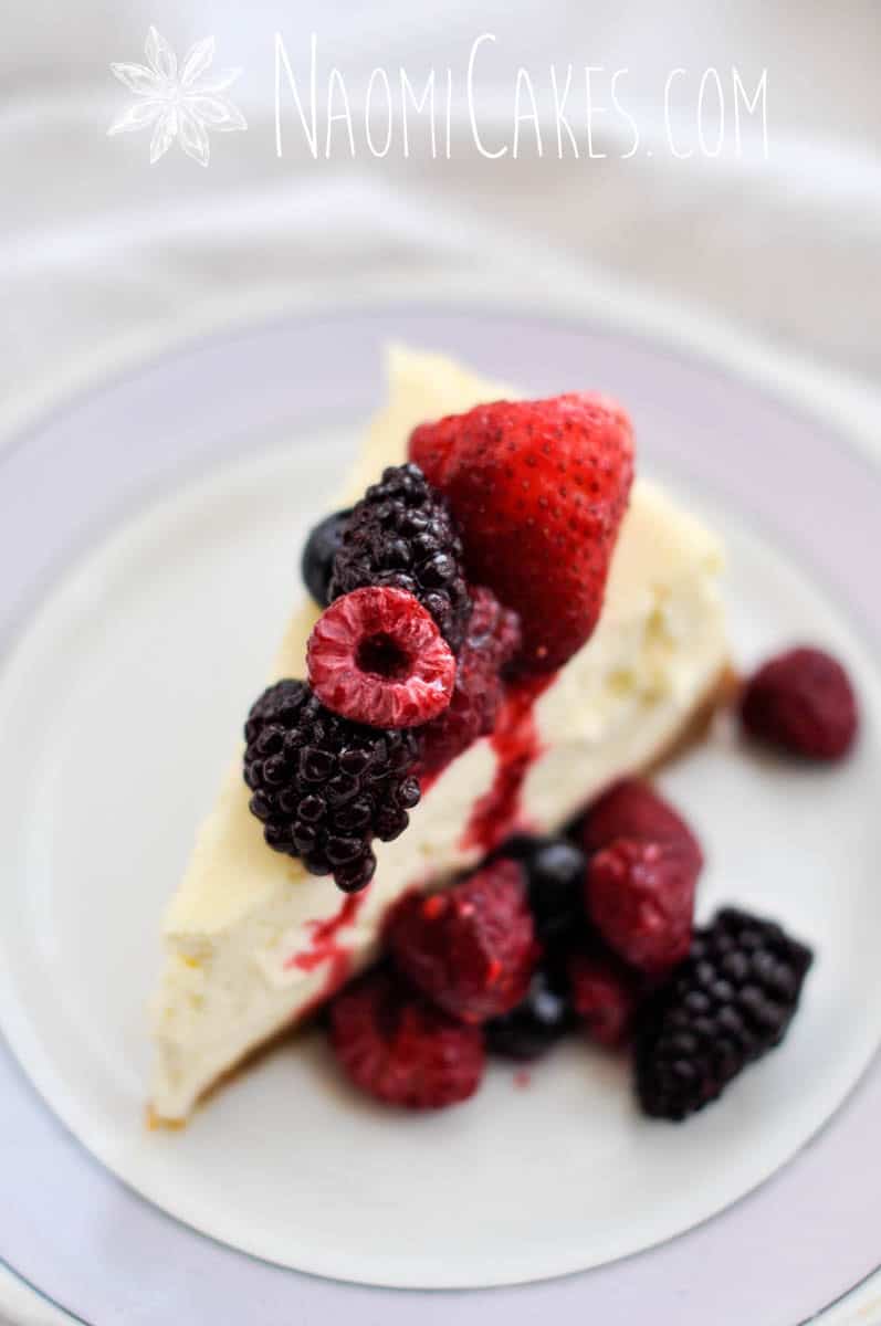 angle overhead view of a slice of cheesecake with frozen fruit on top