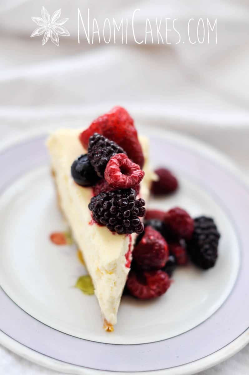 slice of homemade cheesecake with assorted frozen fruit on top
