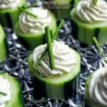 cucumber appetizer with a creamy swirl of filling in the middle and chives on top