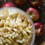 chopped apples in a large measuring pitcher with whole apples in the background