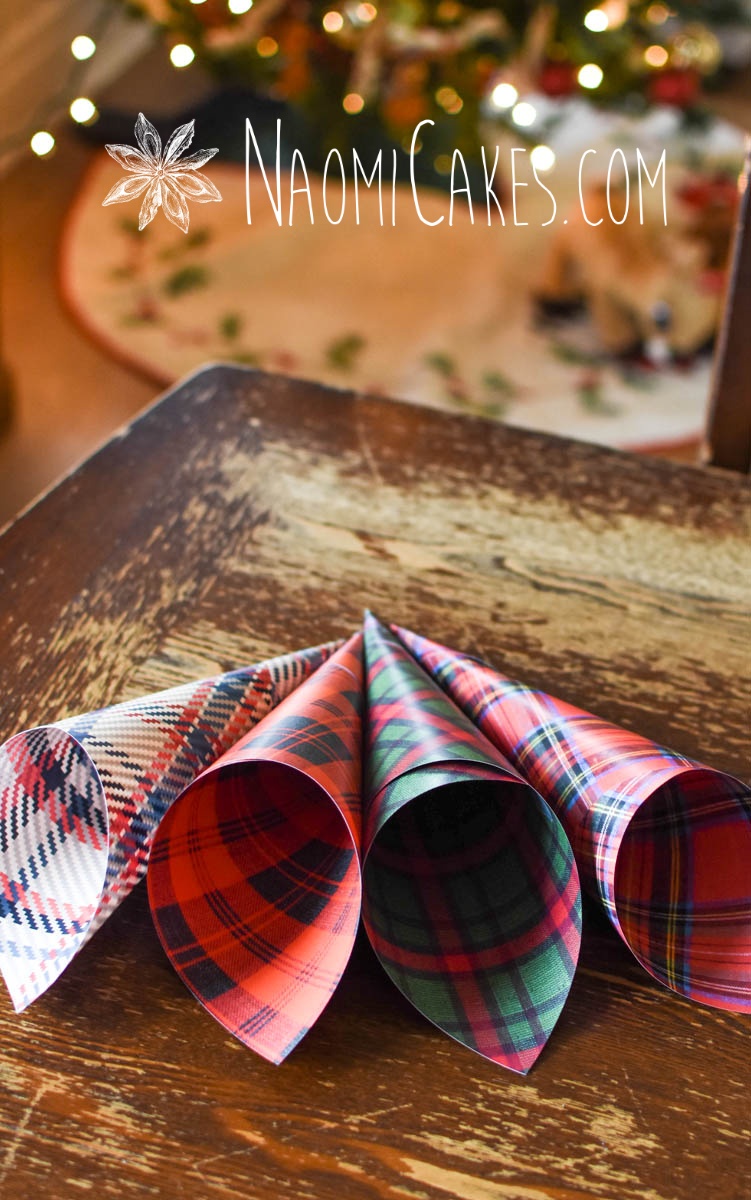 Christmas paper cones in front of a Christmas tree on a wooden table