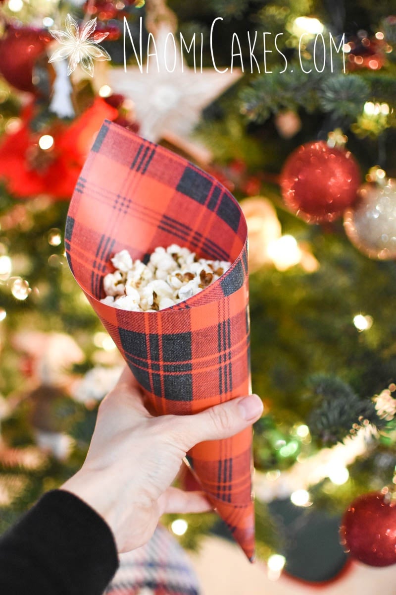 red plaid paper cone with popcorn in it in front of a Christmas tree