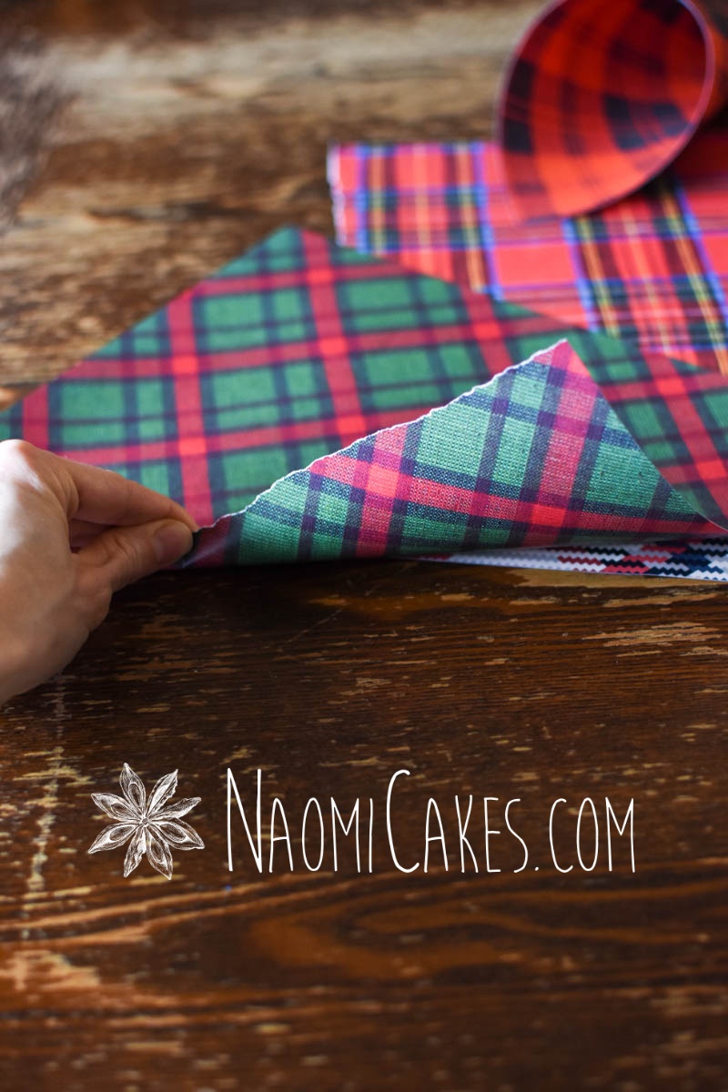 hand making a Christmas snack cup with green plaid paper on wooden table