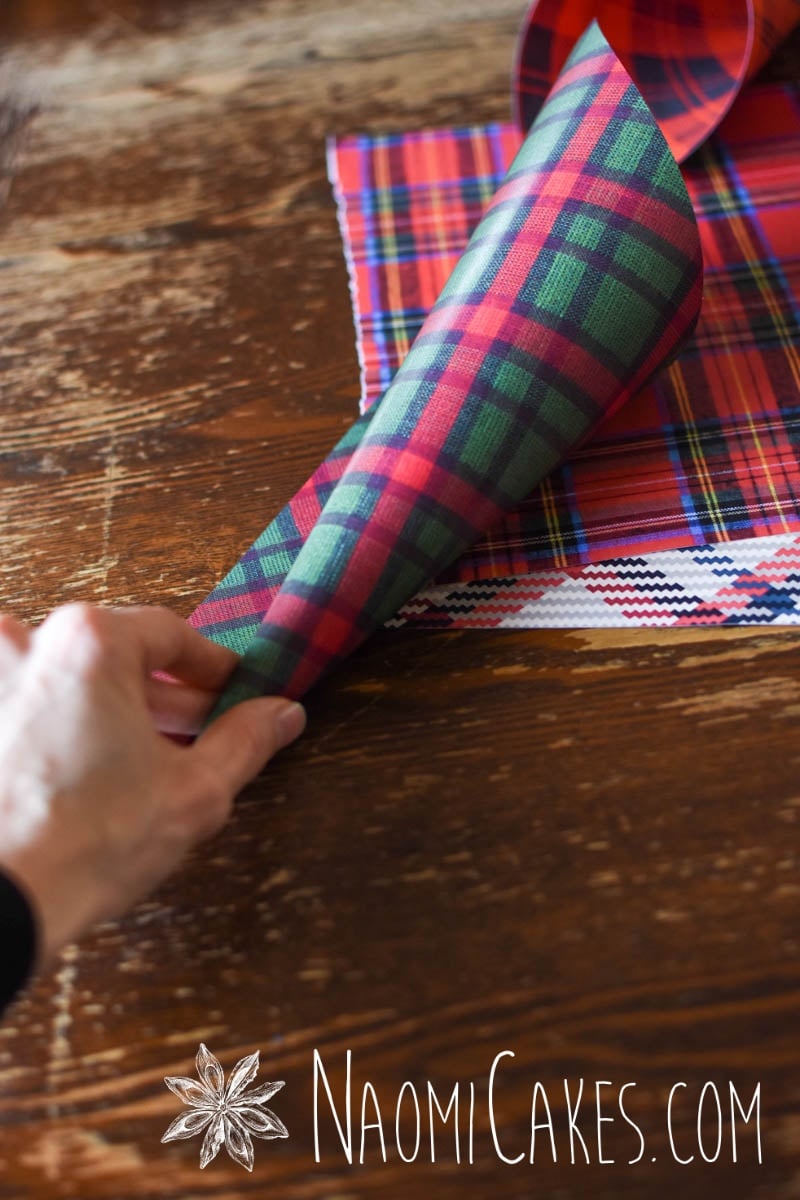 hand making a green plaid Christmas craft cup