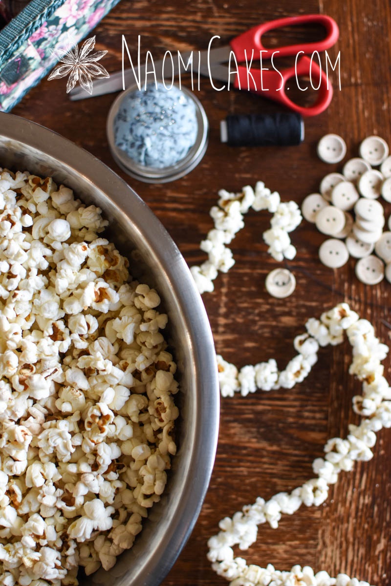 popcorn, garland, buttons, thread, scissors, and pin cushion