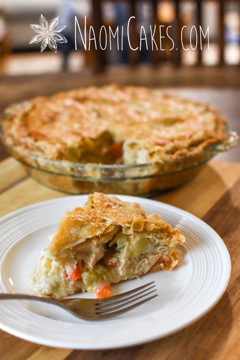 a slice of chicken pie with the whole pie behind it